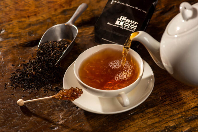 Teezubereitung von Schwarztee mit Teekanne und Teetasse